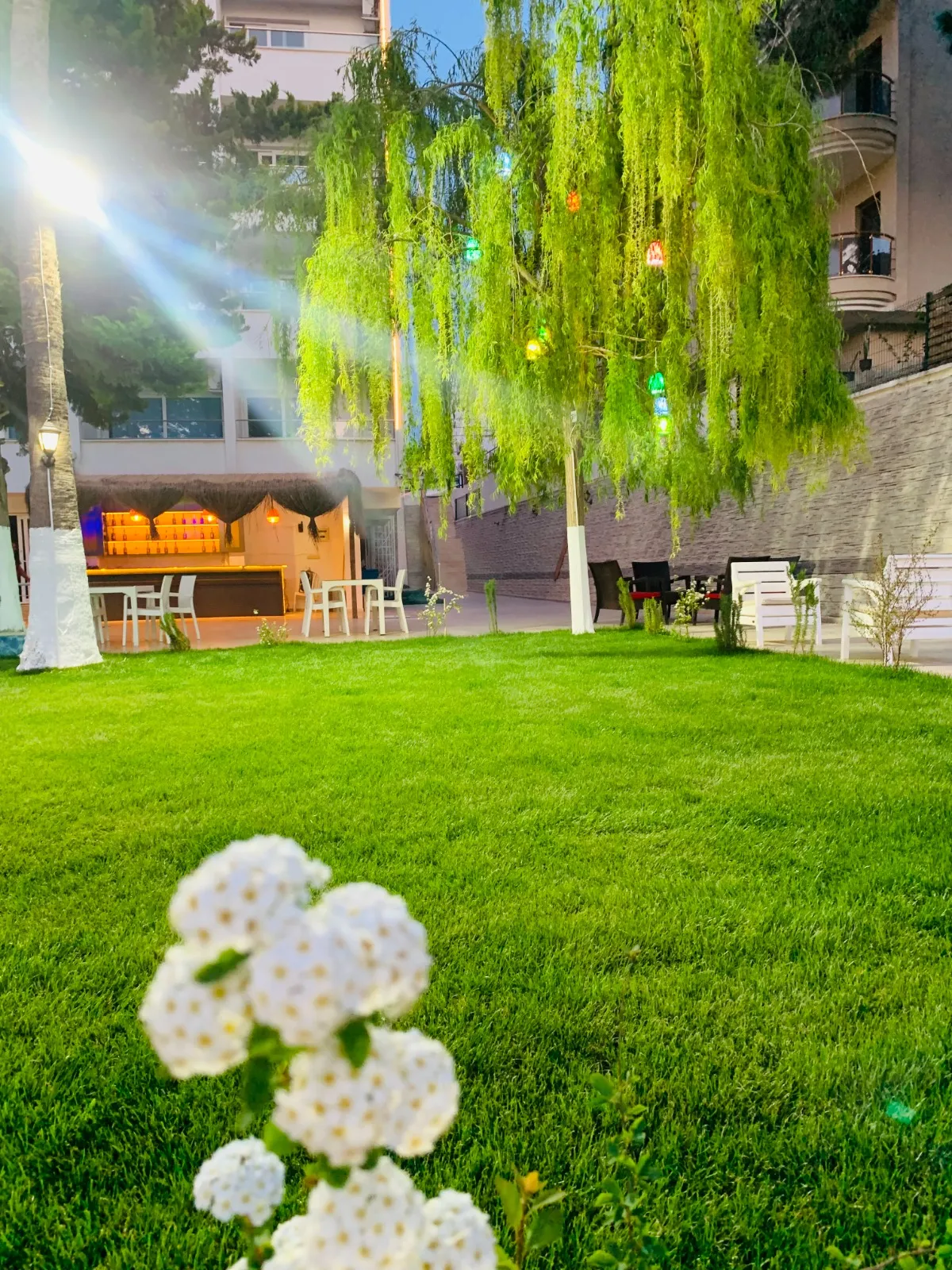 Otel bahçesinde salıncak ve çiçekli yeşil alan
