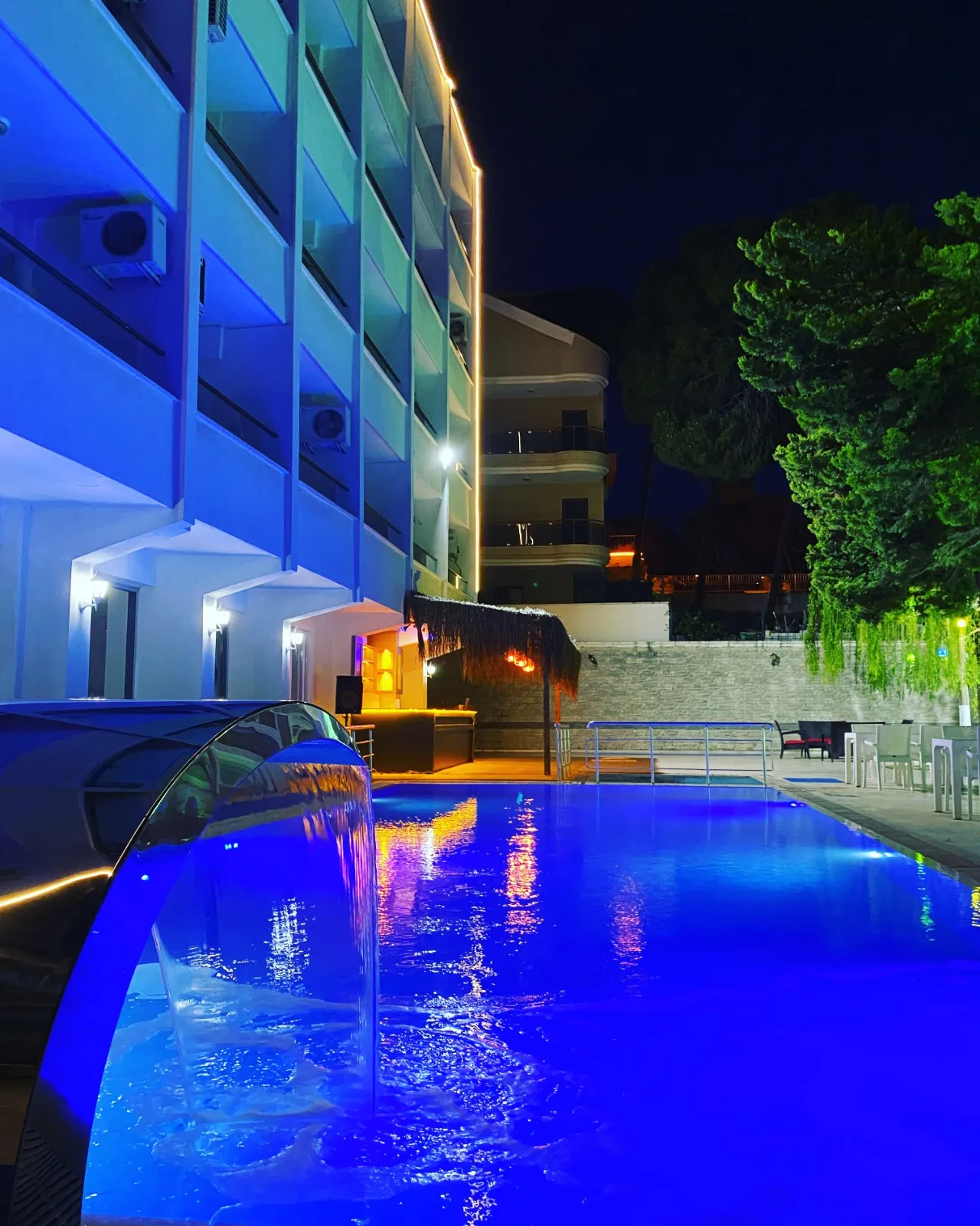 Marla Otel Didim havuzunun gece görünümü — mavi aydınlatma ve şelale