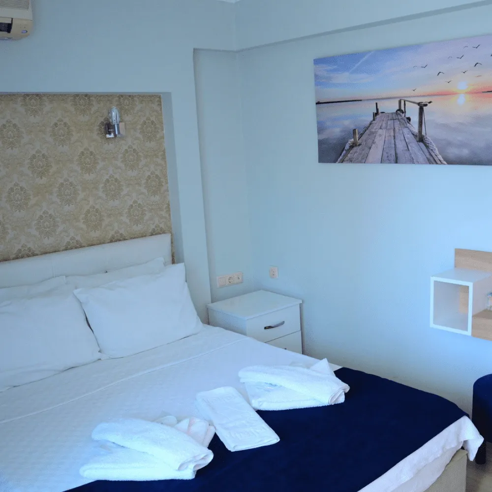 Standart odada yatak başı ve aydınlatma detayı